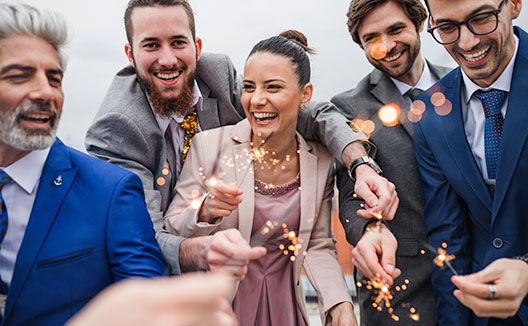 A group of people in business wear holding sparklers
